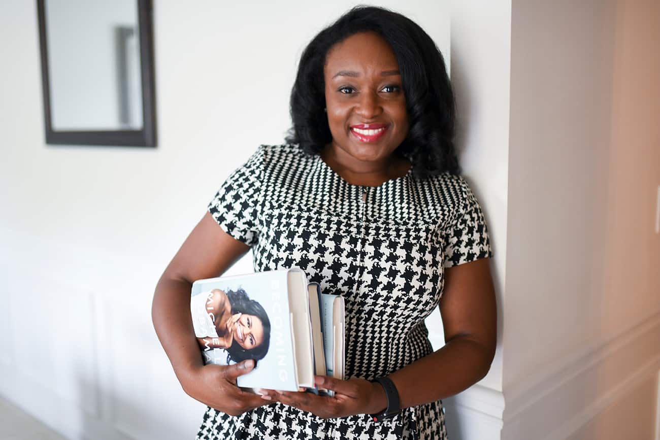 Black woman smiling and holding books