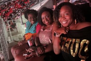 Three Black women smiling at a Beyonce concert