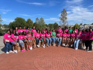Black women dressed in pink and green celebrate 20 years in Alpha Kappa Alpha Sorority, Inc. 