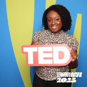 Black woman smiling and holding a TED sign